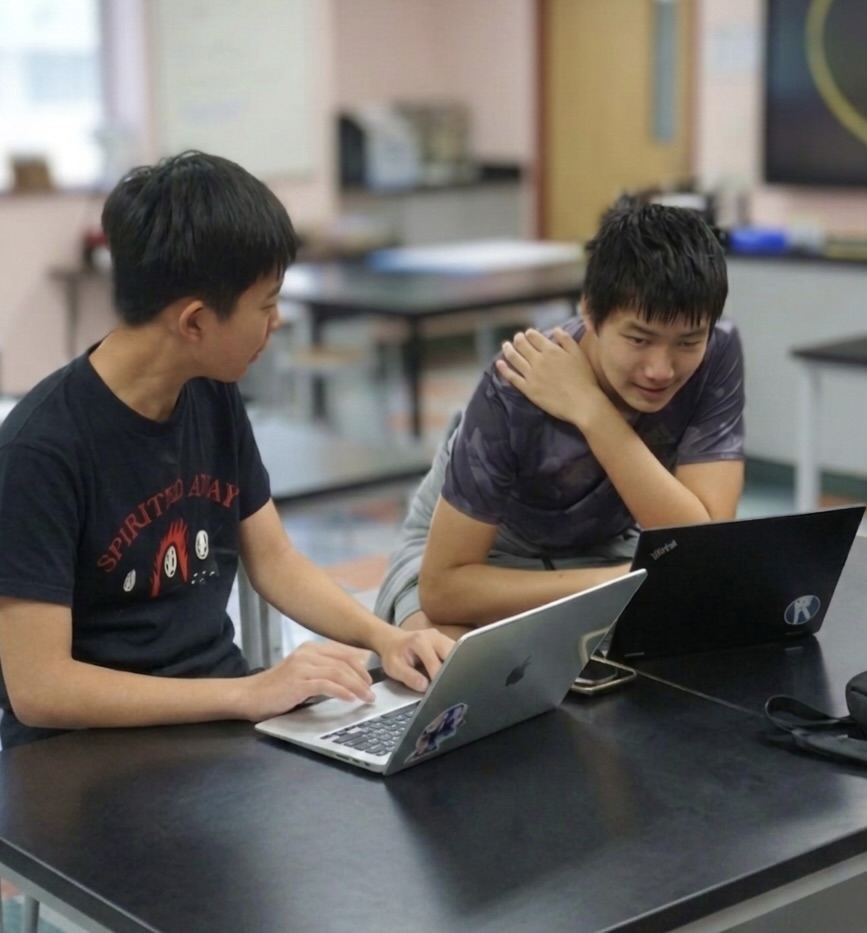 Two Break students working through a flow on laptops during prep